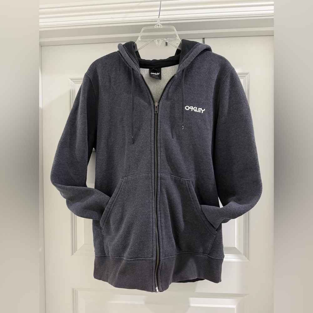 Grey men’s Oakley with working zipper hoodie
Size: medium 
Small stain on back